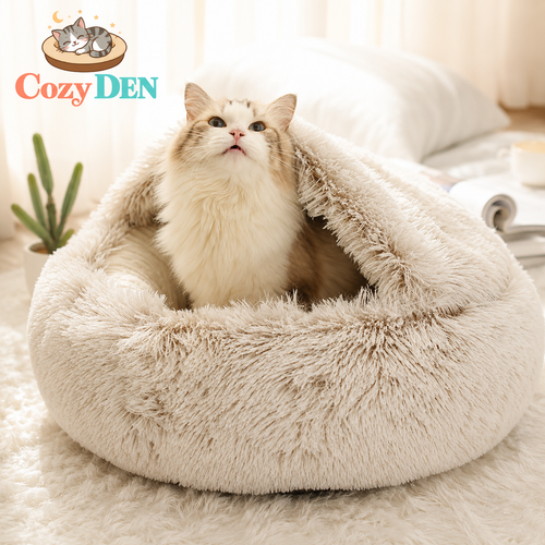 Cat lying in a fluffy beige pet bed with 'Cozy Den' branding.