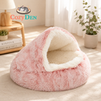 Pink and white pet bed with Cozy Den logo in a room setting.